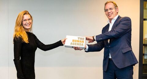 Marinus den Harder (Trebbe) reikt boek The Human Agenda uit aan bouwtalent Rosemarie Pyrek